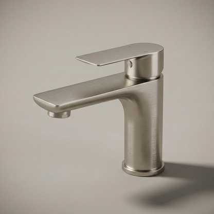 A modern, minimalist single-hole bathroom faucet made of stainless steel, installed on a white speckled quartz countertop against a white subway tile backsplash.