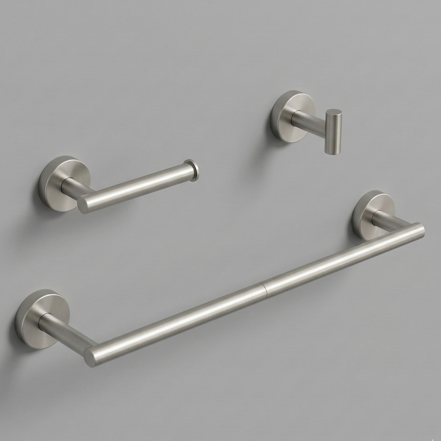 A luxurious, three-piece modern bathroom hardware set in a satin nickel finish, featuring a sleek 24-inch round towel bar, an anti-spin single-post toilet paper holder, and a minimalist cylindrical robe hook floating against a soft, neutral beige background.